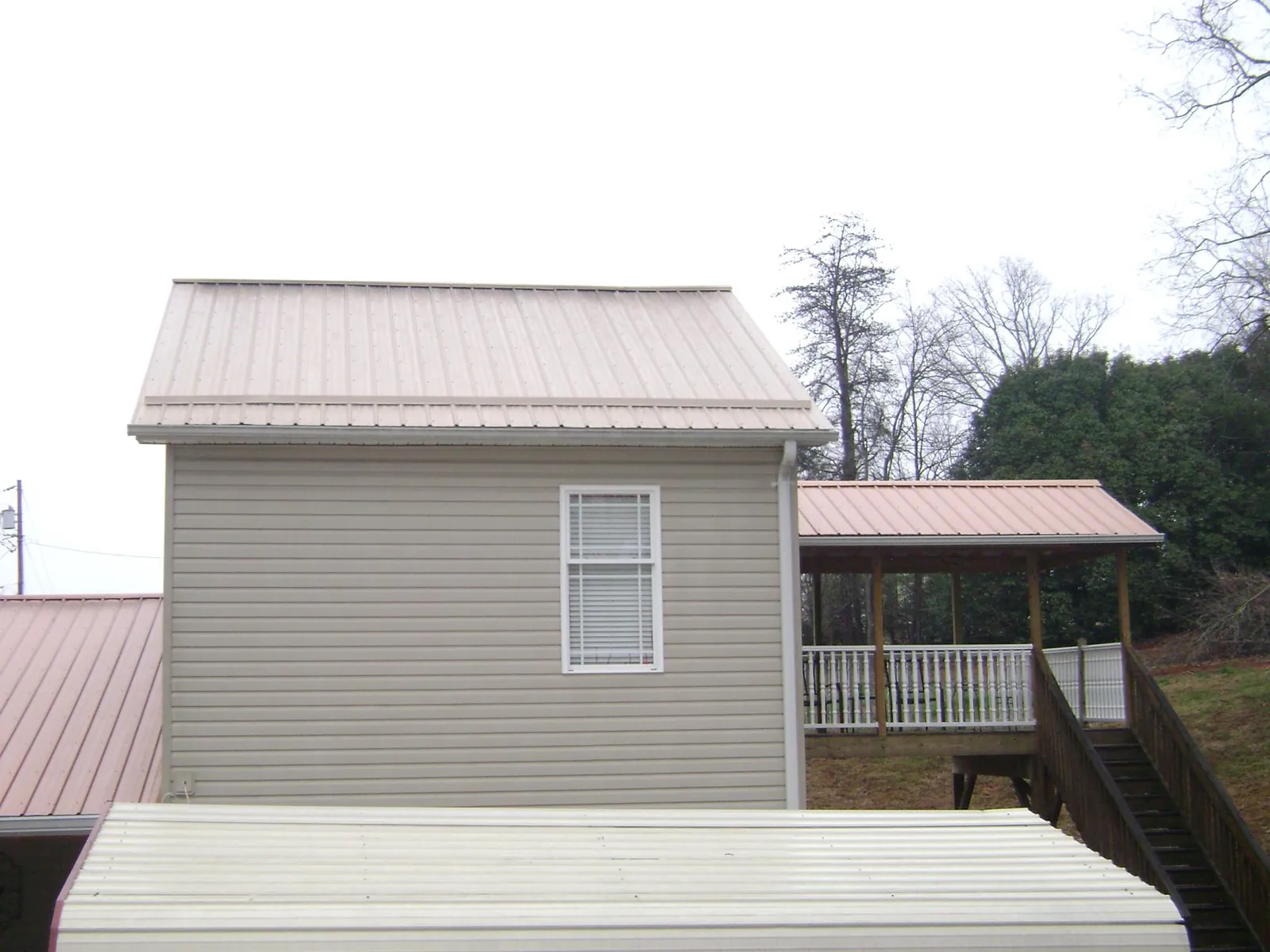 Tan metal roofs on a two story addition and attached porch, from a Roof Replacement job in Rancho Palos Verdes